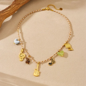Close-up of bohemian woven rope jewelry with musical notes and golden guitar pendants