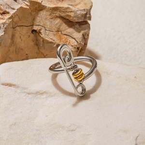 Detail of silver paperclip ring with gold loop on stone, creative minimalist jewelry