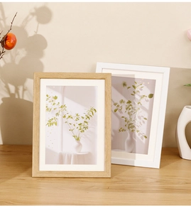 Close-up of Nordic minimalist wood picture frames with white mats on a wooden table