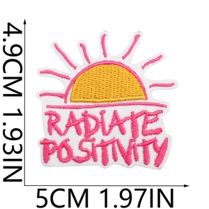 Pink and yellow Radiate Positivity embroidered patch measuring 5cm by 4.9cm on white background