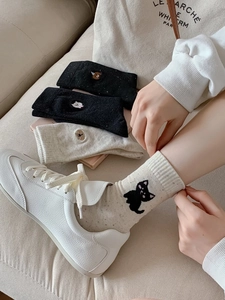 Detail of cotton crew socks featuring delicate animal embroidery and breathable knit texture