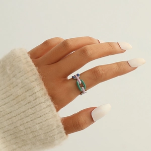 Gros plan détaillé d'une bague chaîne en émail coloré avec des accents de feuilles verts