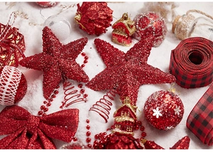 Flat lay of red and white Christmas tree ornaments including stars, bows, and gift boxes