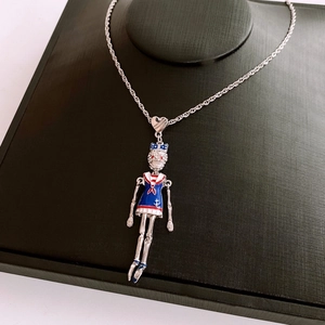 Macro detail of skull pendant wearing a sailor outfit on a black leather jewelry box