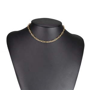 Detailed view of golden paperclip link chain necklace on a black jewelry bust display