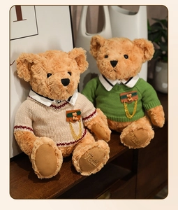 Detail of Teddy bear paws with Teddy embroidery and knit sweaters in warm home setting