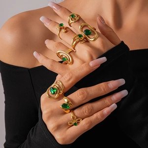 Close-up of vintage gold rings set with emerald green stones and geometric textures
