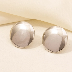 Close-up of circular polished silver 304 stainless steel stud earrings on fabric