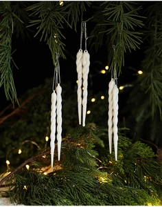 White spiral icicle Christmas tree ornaments with glitter on green pine branches
