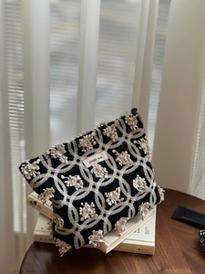 Vue détaillée de la broderie d'anémone sur une pochette élégante en toile noire