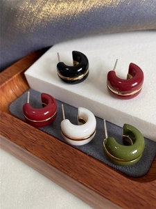 Detail view of retro C-shaped enamel stud earrings in four elegant vintage colors