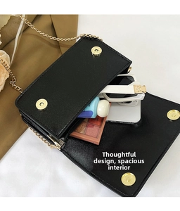 Detail view of the black cross-grain leather crossbody bag showing spacious interior capacity