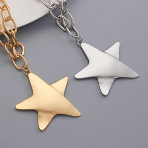 Detailed view of chunky gold and silver star pendants with polished metallic finish