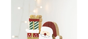 Gros plan détaillé d'une figurine de Père Noël en bois avec des cadeaux de Noël colorés