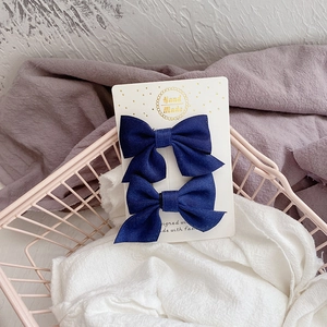 Gros plan d'un ensemble de barrettes à nœud en tissu bleu marine sur carte papier