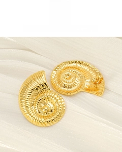 Dettaglio macro di orecchini a conchiglia placcati in oro 18K con design a spirale