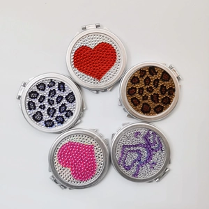 Flat lay of five mini folding pocket mirrors featuring sparkling rhinestone patterns and silver frames