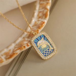 Detail of gold tarot necklace pendant with blue enamel dolphin and tiny crystals