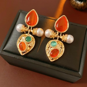 Macro view of vintage palace style earrings with cat eye stones and pearls on jewelry box