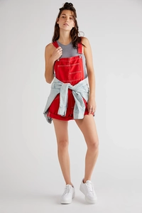 Detail of red loose-fit denim overalls with multiple pockets for a casual summer look