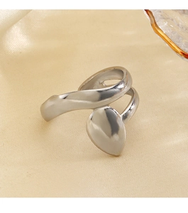 Macro shot of minimalist silver leaf ring with smooth finish on beige satin fabric