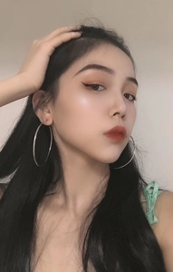 Close-up of a model wearing large silver stainless steel hoop earrings in minimalist style