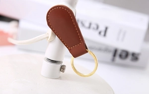 Brown leather magnetic cable organizer with gold metal buckle for desktop storage
