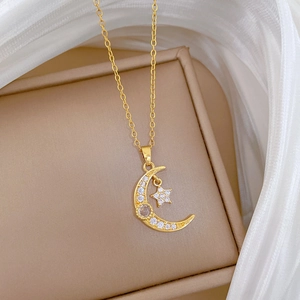 Détail du collier étoile et lune doré avec zircons sur un élégant coffret à bijoux