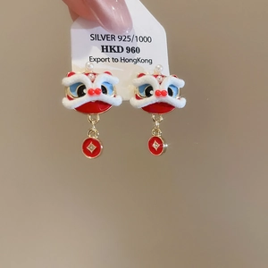 Detailed macro view of red lion dance earrings with white fur trim and silver 925 needle