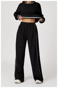Detail view of black long-sleeve sweatshirt with white side stripes and ribbed cuffs