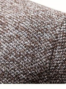 Detailed close-up of brown and white textured knit fabric for a thick men's sweater
