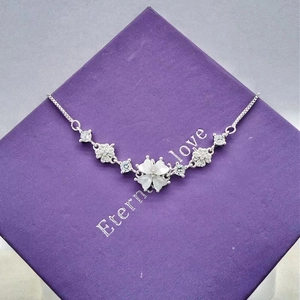 Detail view of silver clover bracelet with cat eye stone on purple jewelry box