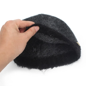 Dark grey knitted bucket hat with internal lining and brand label showing material details