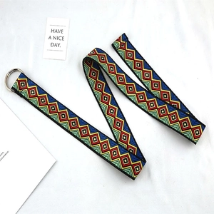 Detail of bohemian geometric pattern canvas belt with silver double D-ring buckle