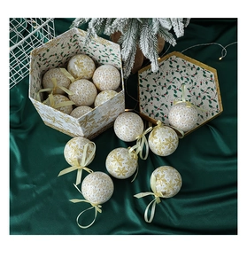 Close-up of white and gold snowflake Christmas balls on dark green silk fabric background