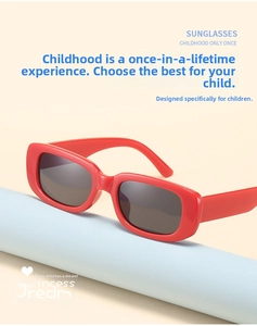 Detail of red children's square sunglasses with thick frames and black lenses on a blue stand
