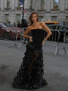 Detail of black strapless evening dress featuring 3D polka dots and sheer mesh paneling