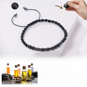 Détail de l'application d'huile essentielle sur le bracelet diffuseur en pierre de lave