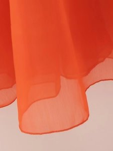 Detail shot of orange chiffon dress showing high-quality hem stitching and rolled edge finish