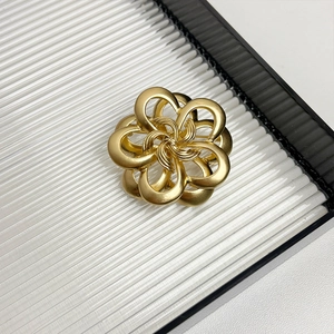 Detailed view of luxury gold camellia flower brooch with intricate metal layers