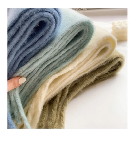 Close-up of soft thick mohair scarves in blue, beige, and olive green textures