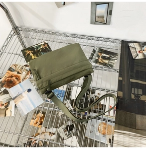 Detail of army green nylon messenger bag texture on industrial metal rack