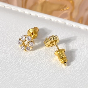 Macro view of gold-plated flower stud earrings with sparkling round zirconia accents