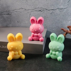 Detailed view of matte rabbit figurines in yellow, pink and green with bowties