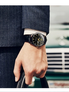 Classic men's watch with black dial and leather strap worn in professional business setting