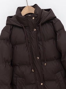 Detail of dark brown padded parka featuring gold metal snaps and hood drawstring cords