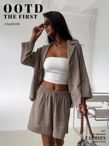 Detail of linen short set texture featuring a beige blazer and drawstring shorts