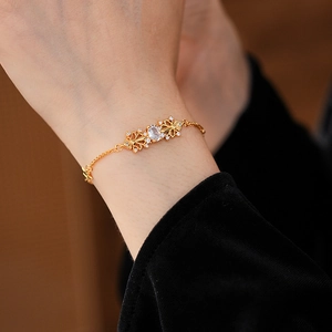 Dettaglio del bracciale iris vintage dorato con zircone e accenti floreali traforati