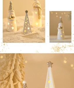 Detail of ceramic Christmas Santa figurines with warm LED light and golden glitter finish