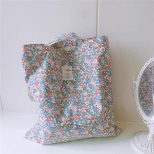 Floral cotton tote bag with small blue and pink blossoms and decorative label detail